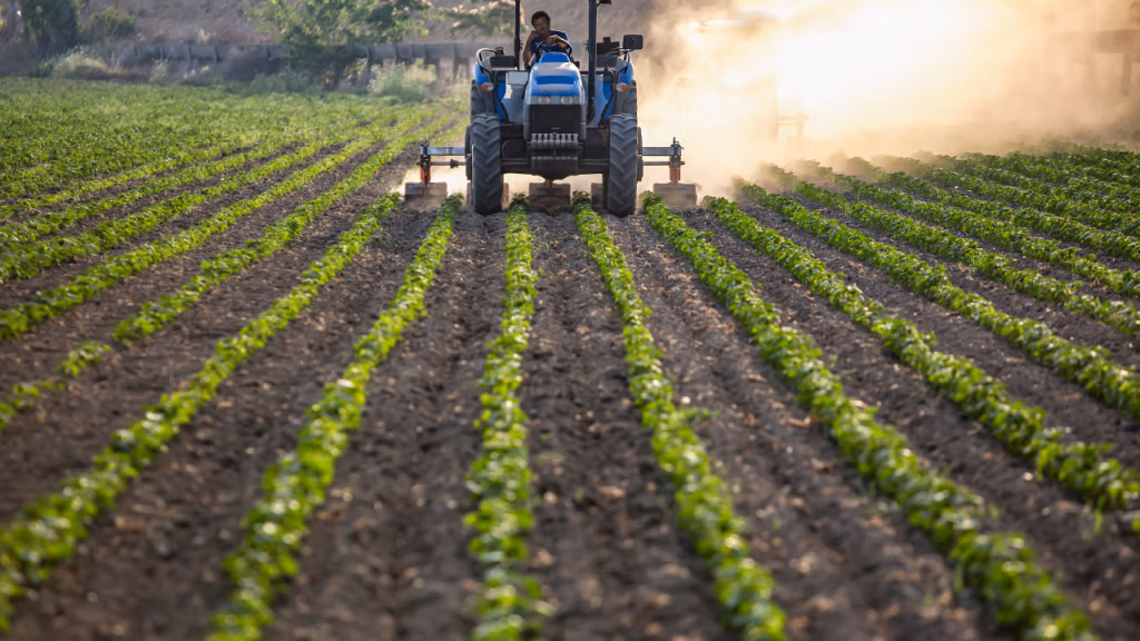 agricultor conduciendo su tractor en su cosecha con un generador de ozono para agricultura
